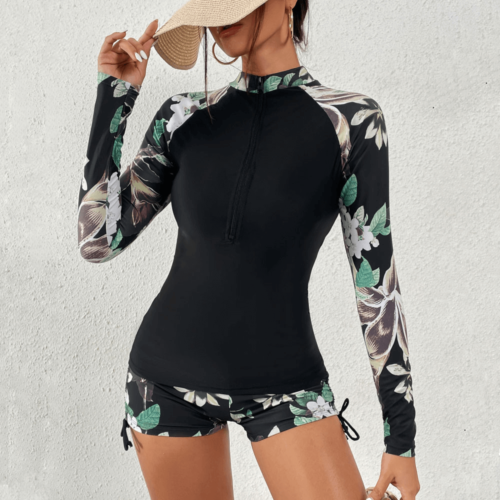 Stylish split women's long sleeve rash guard swimwear, black with floral pattern, perfect for surfing and beach activities.